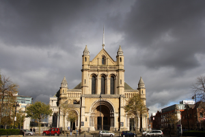 St Anne’s cathedral, Belfast front view with a thundery sky background