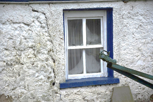 The layers below the lime harling can be seen in this stone and mud-walled building, which is in need of repair