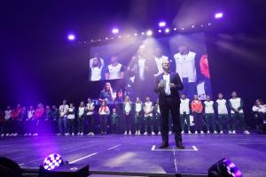 Communities Minister on stage at the Paris Celebration event at the SSE Arena