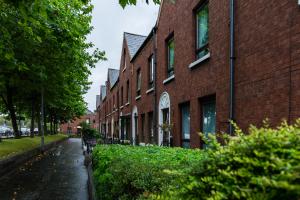 Image shows row of red brick terrace houses